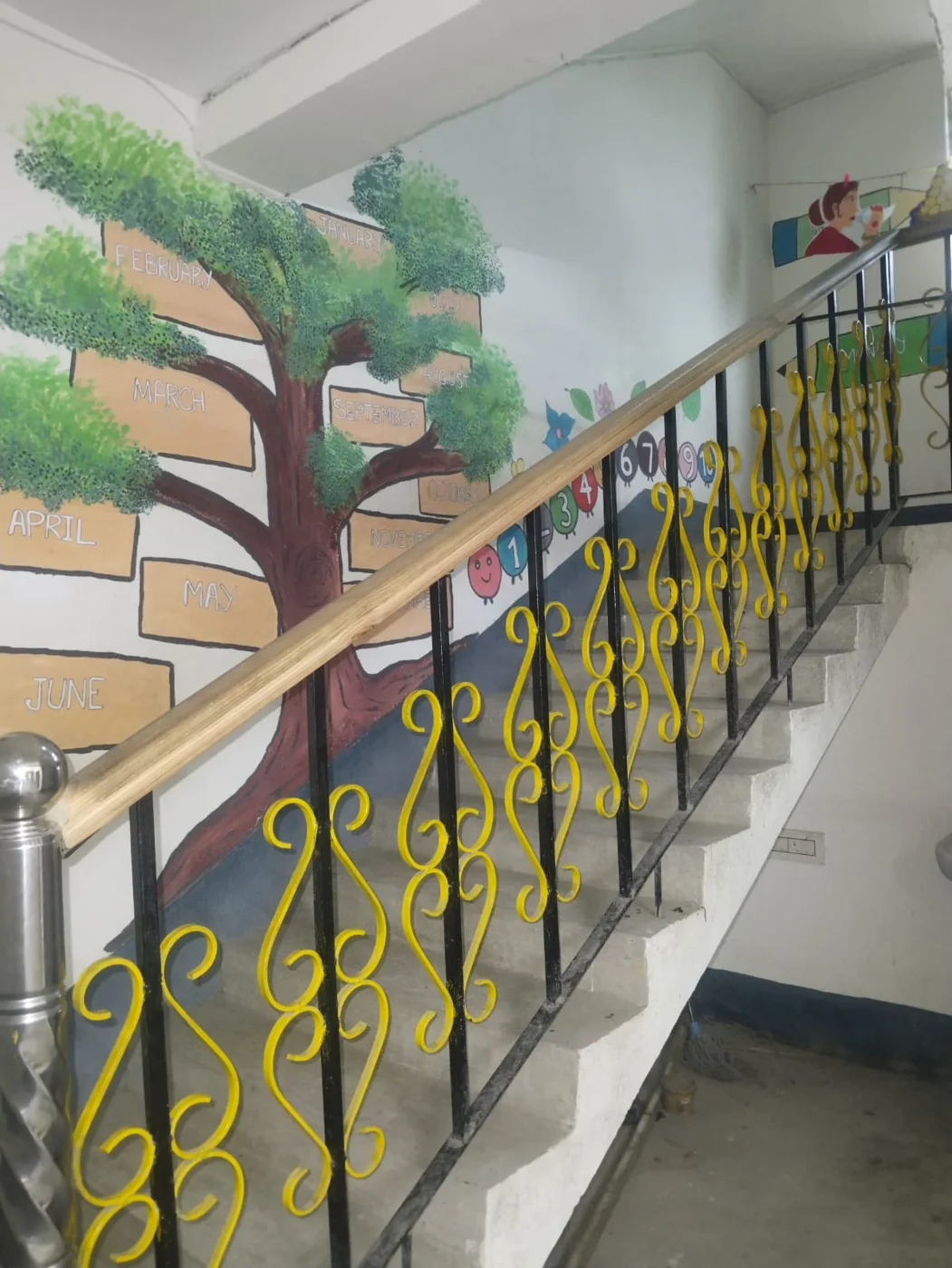 A colourful tree and book mural beside the school staircase